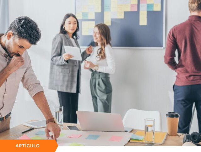 Consultores colaborando en un espacio de trabajo moderno sobre procesos de innovación empresarial y gestión de proyectos para un portafolio estratégico.