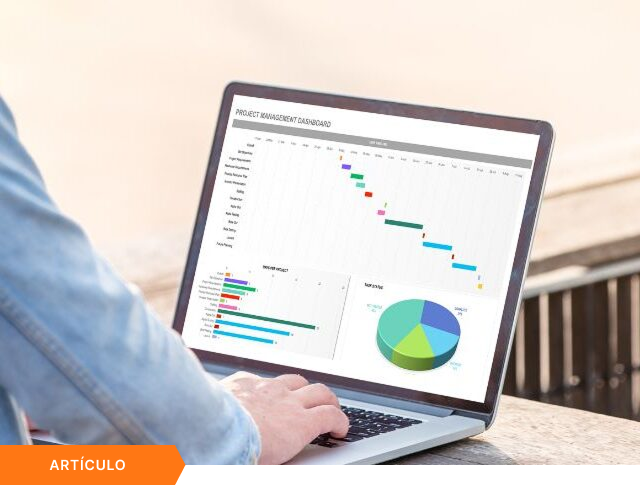 Profesional consultando un artículo sobre un panel de control en su laptop para la optimización de la gestión de proyectos e innovación empresarial dentro de un portafolio estratégico.