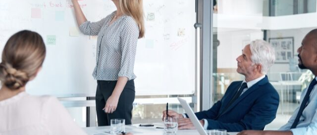 Equipo de profesionales colaborando en una sesión de planificación estratégica en una pizarra para la gestión de proyectos y la innovación empresarial, enmarcado como imagen de cabecera para un artículo.