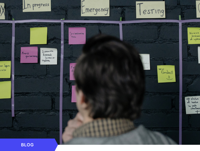 Profesional analizando un tablero Kanban físico con notas adhesivas para la gestión ágil de proyectos de innovación empresarial, presentado como imagen de cabecera para una entrada de blog.