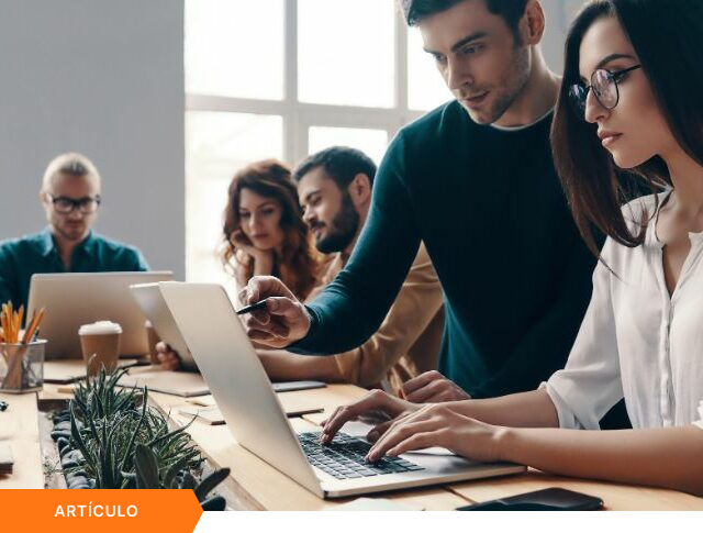 Portada de artículo que muestra a un equipo colaborando en una laptop dentro de una oficina moderna, con etiqueta naranja de ARTÍCULO en la esquina inferior.