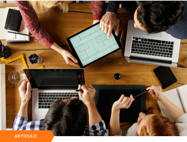 Vista superior de un equipo multidisciplinario trabajando en diseño técnico con laptops y tablets, con etiqueta naranja de ARTÍCULO en la esquina inferior.