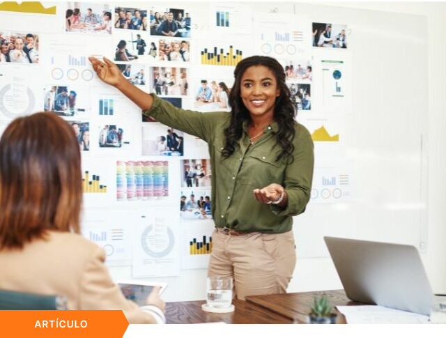 Imagen de portada para artículo mostrando a una profesional presentando un panel de métricas y fotografías de equipo en una pizarra blanca, con una etiqueta naranja de ARTÍCULO en la esquina inferior izquierda.