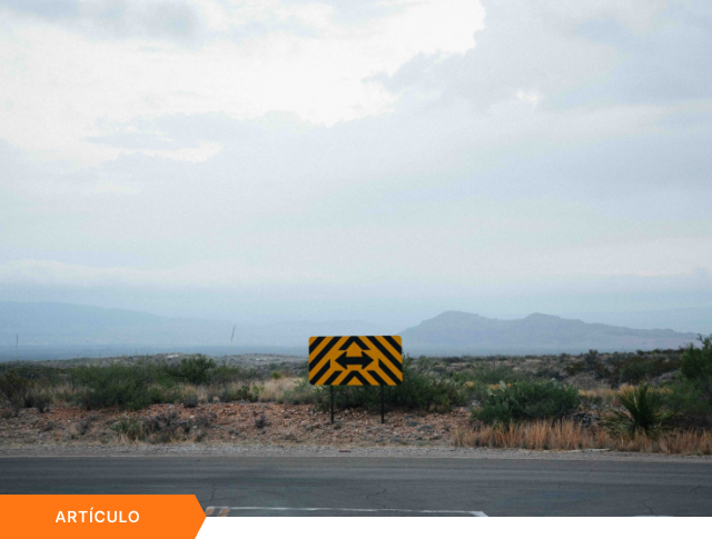 Portada de artículo que muestra una señal de tránsito con flechas en direcciones opuestas en un paisaje desértico, con etiqueta naranja de ARTÍCULO en la esquina inferior izquierda.