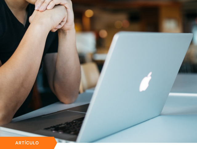 Portada de artículo que muestra un primer plano de un profesional trabajando frente a una laptop en una oficina, con etiqueta naranja de ARTÍCULO en la esquina inferior.