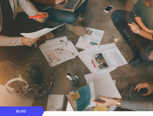Imagen de portada para blog que muestra una sesión de ideación creativa con un equipo trabajando en el suelo con documentos y esquemas, incluyendo la etiqueta visual de BLOG en color azul.